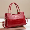 Red crocodile pattern tote bag in glossy patent leather with gold hardware handles - Red
