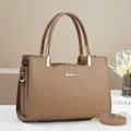 Detail of crocodile embossed leather tote bag with gold logo and detachable shoulder strap - Khaki