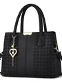 Close-up of black crossbody bag with quilted texture, gold heart charm and pearl detail - Black