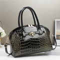 Glossy black crocodile-embossed leather handbag with gold hardware and shoulder strap - Black