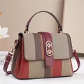 Primer plano del tejido trenzado y el asa de cuero de este bolso de mano elegante - Rojo