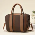 Detailed close-up of vertical striped woven handbag with brown leather flap and gold hardware - Brown