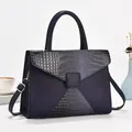Détail du sac bleu marine montrant le mélange de textures de cuir et la boucle en métal doré - Bleu clair