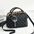 Quilted black handbag with gold studs, top handle, long strap and decorative pompom - Black
