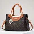 Brown monogram crossbody bag with gold metal logo and pearl heart charm detail - Coffee and Yellow