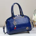 Dunkelblaue Handtasche mit Krokodilmuster, Goldbeschlägen und schicken Accessoires - Blau