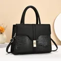Detail of black tote bag featuring matte lychee and glossy crocodile embossed textures - Black