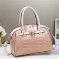 Pink crocodile-embossed handbag with gold hardware and adjustable shoulder strap - Pink