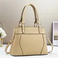 Detail of beige lychee leather tote showing golden rivets and black edge paint finish - Khaki