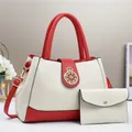 Dettaglio borsa in pelle crema con finiture rosse e fibbia a corona in metallo dorato - Bianco Sporco