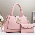 Dettaglio borsa rosa in pelle PU a grana di litchi con emblema dorato e mini pochette - Rosa