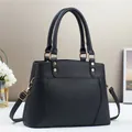 Detail of black lychee grain texture and gold hardware on elegant women's handbag - Black