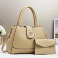 Dettaglio della borsa a mano beige in pelle martellata con decorazione corona in metallo - Kaki