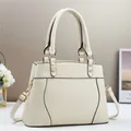Detail of cream white pebbled leather handbag with gold rivets and hardware - Off White