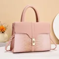 Detail of pink tote bag showing crocodile texture stitching and golden twist lock - Pink