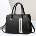 Détail du sac cabas en cuir bicolore avec ferrures dorées et rayures contrastées - Noir