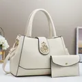 Dettaglio della borsa tote color crema con fibbia a corona dorata e mini pochette coordinata - Bianco avorio
