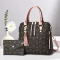 Détail du sac monogramme marron avec pompon rose et son portefeuille assorti de luxe - Rose