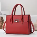 Dettaglio della borsa in pelle bordeaux con elegante chiusura dorata e anelli in metallo - Rosso Giuggiola