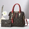 Détail du sac cabas marron et pochette assortie avec lettres dorées et pompon rouge élégant - Rouge