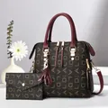 Detail of printed tote bag set with matching wallet and cat charm on white surface - Wine Red