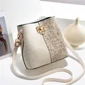 Détail du sac seau en tweed bicolore avec fermoir doré et bandoulière en cuir crème - Blanc Cassé