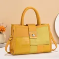 Detail of yellow patchwork tote with crocodile texture and gold metal clasp closure - Bright Yellow