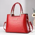 Bolso de mano rojo en charol con relieve de cocodrilo y detalles dorados - Burdeos