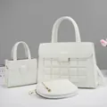Detailed macro view of 3-piece white tote set with embossed patterns and gold chain - White