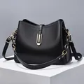 Minimalistische zwarte lederen crossbody tas met gouden kettingriem op displaystandaard - Zwart