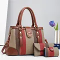 Detailed macro view of the 3-piece striped handbag set with golden metal rings and studs - Red
