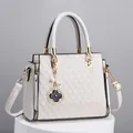 Elegant ivory white quilted tote bag with golden hardware and four-leaf clover charm - Off White