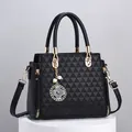Elegant black embossed tote bag with golden charm and removable crossbody strap - Black