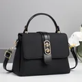 Detail of the black textured handbag with oval gold hardware and floral background décor - Black