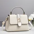 Detail showing creamy woven texture, gold twist lock and smooth leather trim of the bag - 24x10x16cm / Off White