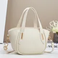 Dettaglio macro della borsa in pelle color crema con eleganti finiture in metallo oro - Bianco