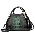 Close-up of green crocodile texture and black patent leather with gold metal accents - Green
