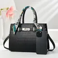 Vista detallada del bolso negro con grabado de cocodrilo, pañuelo y cierre de metal - Negro