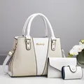 Close-up of a stylish white three-piece handbag set with gold hardware and logo - Off White