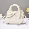 Elegant cream-white handbag featuring a large bow design and round handle for women - Off White