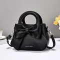 Black PU leather handbag with large bow detail and adjustable shoulder strap for women - Black