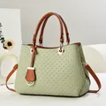 Close-up of woven texture on green tote bag with brown leather handle and gold hardware - Green