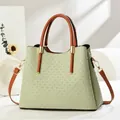 Detail of light green woven texture handbag with brown leather strap and gold hardware - Green