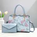 Hellblaue Handtasche Set mit Blumenstickerei und goldenen Metallbeschlägen - Bestickte Haupttasche Und Umschlag-Kleintasche / Hellblau
