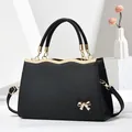 Elegant black Saffiano leather tote with golden bow detail and adjustable shoulder strap - Black