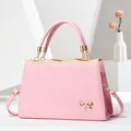 Elegant light pink textured leather tote bag with golden bow and top handle details - Light Pink