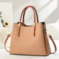 Close-up of earth-tone handbag with geometric woven texture and gold metal hardware - Khaki