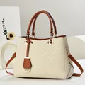 Close-up of woven texture handbag with brown leather straps and gold metal details - Off White