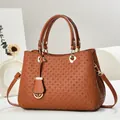 Detailed view of brown woven texture on shoulder bag with premium golden hardware - Earthy Yellow