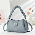 Detalle de bolso de cuero gris azulado con asa plisada de nube y cierre giratorio plateado - Azul